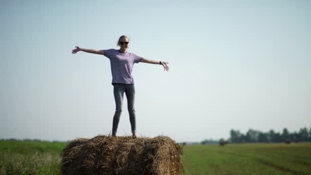 Pretty girl is standing on haystacks — Stock Video