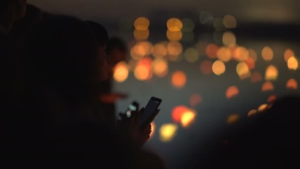 Silhouette of a woman with a phone on a festival of water lanterns — Stock Video