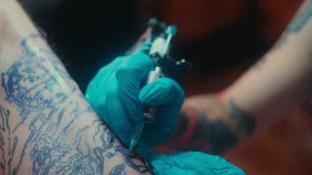 Close-up van Tattoo patroon. Master Tattoo in medische steriele handschoenen patronen — Stockvideo