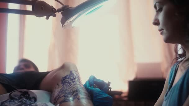 Dziewczyna trzyma maszynę tatuażu i stosowane w wzór na skórze — Wideo stockowe