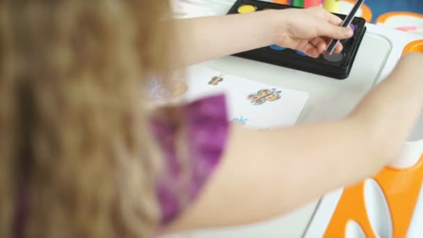 Dítě kreslí. Holčička, která si kresluje motýly s barevnými tužkami. — Stock video