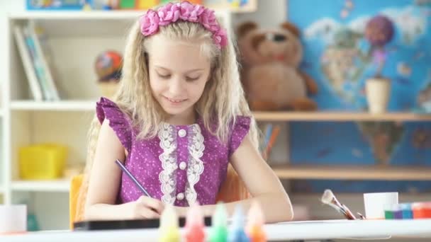 Menina direita cuidadosamente pinta usando lápis coloridos . — Vídeo de Stock