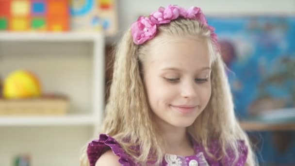 Menina bonita com cabelo loiro sorrindo e desenho com lápis colorido — Vídeo de Stock