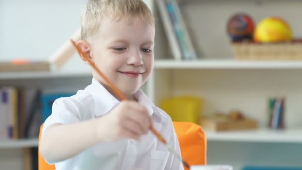 Lindo niño de 5-7 años está dibujando y usando acuarela — Vídeos de Stock