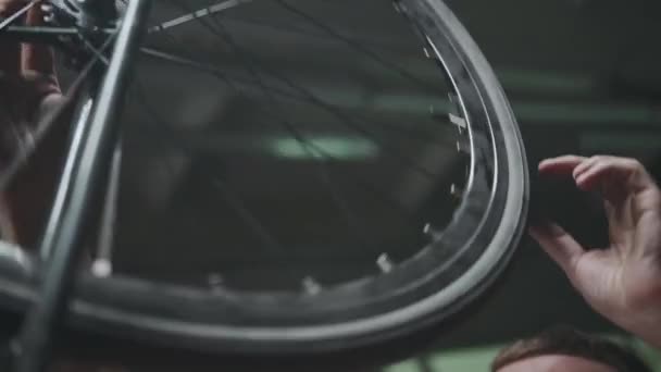 Der Fahrradmechaniker untersucht das Rad sorgfältig, dreht es. — Stockvideo