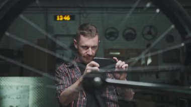 Bisikletçi satmak ya da tamir için yedek parça bulmak için tekerlek resimleri çekiyor