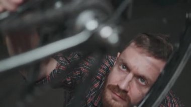 Pit durağındaki erkek bisikletçi: tekerleği tamir ediyor. Servis bakımı.