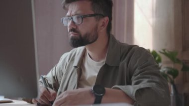 Gözlüklü erkek tasarımcı grafik tableti kullanıyor