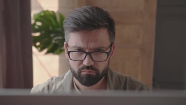 Ekspresi wajah seorang pria dalam proses bekerja di komputer — Stok Video