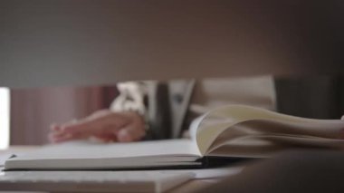 Bir adam sayfaları bir not defteriyle çevirir, yakın plan, sadece eller