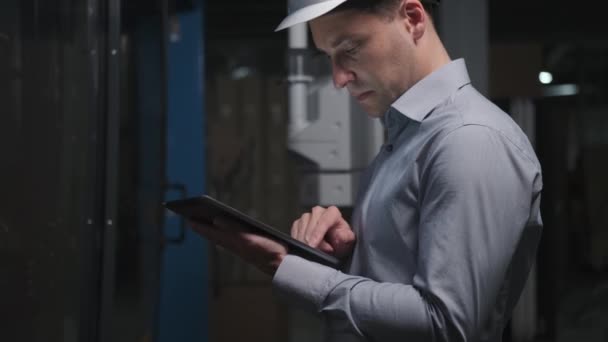 Бизнесмен на заводе проверяет оборудование планшетом. — стоковое видео