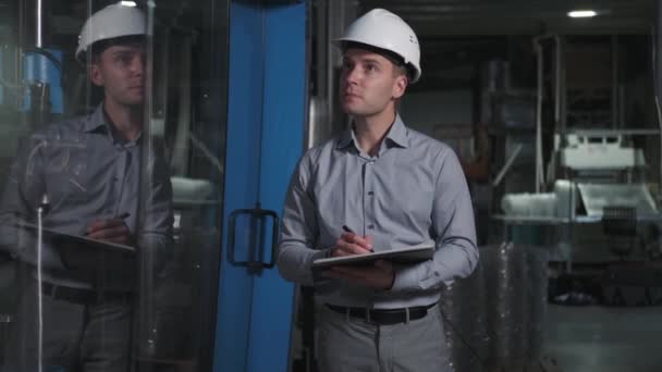 Hombre profesional con casco trabajando en el control de calidad en la producción — Vídeos de Stock