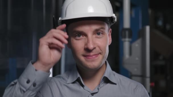 Ingeniero profesional en casco eleva cabeza y ajusta casco — Vídeos de Stock