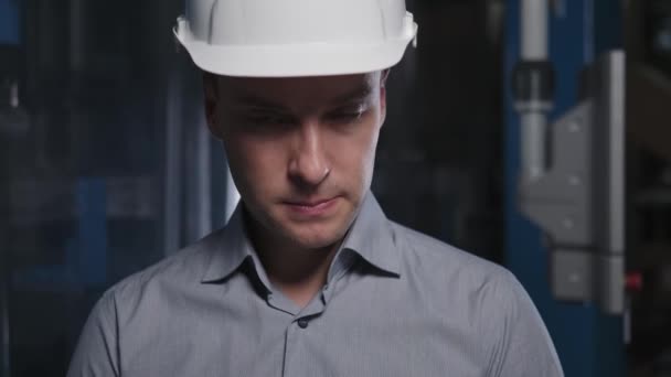 Um jovem gerente de topo de sucesso, um engenheiro em um capacete — Vídeo de Stock