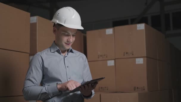 Ouvrier d'entrepôt avec un sourire de tablette et regardant la caméra — Video