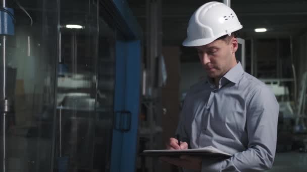 Ingeniero de hombre con casco en ambiente industrial usando tableta — Vídeos de Stock