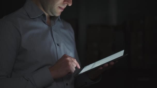 Un hombre profesional con casco y camisa usa una tableta en un almacén — Vídeos de Stock