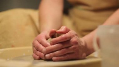 Potter özel araçları kil kolları. Usta güveç. Stüdyodaki yaratıcı süreç. Bükülmüş çömlekçi tekerleği. İnsan bir sanat eseri yaratır. Güzellik yaratma yeteneği. Usta kil yoğurun. 