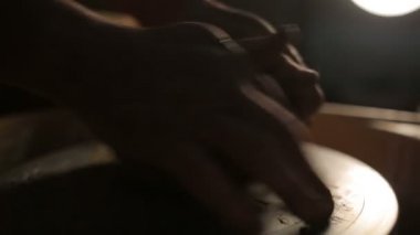 Bir çömlekçinin elleri, çemberin üzerinde toprak kavanozu yaratıyor.