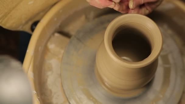 Potter specialverktyg hanterar lera. Master lerkruka. Den kreativa processen i studion. Twisted Potter ' s Wheel. Man skapar ett konstverk. Förmågan att skapa skönhet. Befälhavaren knäböjer leran. — Stockvideo