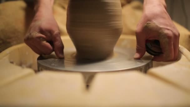 Potter specialverktyg hanterar lera. Master lerkruka. Den kreativa processen i studion. Twisted Potter ' s Wheel. Man skapar ett konstverk. Förmågan att skapa skönhet. Befälhavaren knäböjer leran. — Stockvideo