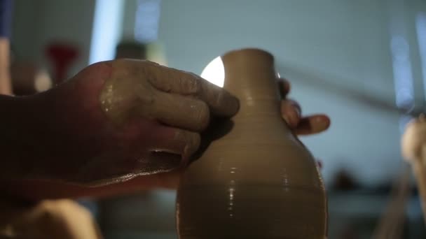 Χέρια ενός αγγειοπλάστη, δημιουργώντας ένα πήλινο βάζο στον κύκλο — Αρχείο Βίντεο