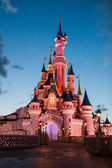 Disneyland Paříž hrad osvětlený při západu slunce.