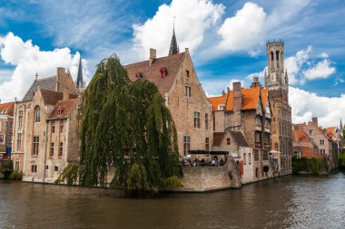 Güneşli bir günde Bruges'deki kanal üzerinde binalar