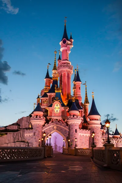 Disneyland Parijs kasteel verlicht bij zonsondergang. — Stockfoto