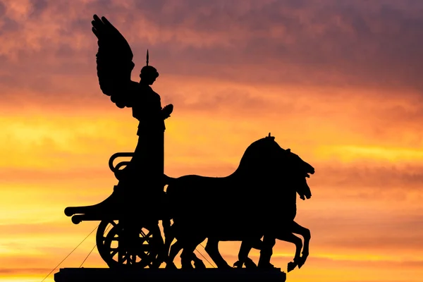 Rome at dusk: silhouette of the goddess Victoria over the National Monument to Vittorio Emanuele II — Stock Photo, Image