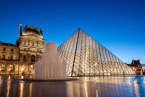 Музей Лувр в сутінках в Парижі — стокове фото