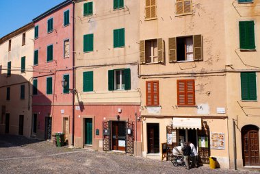 Alghero, Sardinya / İtalya / 3 Mayıs 2009: Güzel İtalyan şehrinin eski bir kasabası. Eski mahalledeki uzun, basit, tarihi binalar. Renkli sıva cepheleri. Güneşli yaz günü.