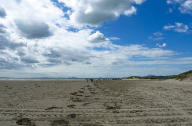 Kara kayalık kumlar, Pothmadog, Galler dramatik gökyüzü engin kumlar üzerinde bir yaz günü Ufuktaki uzak kardan dağlar Galler deniz manzarası kopyala uzay