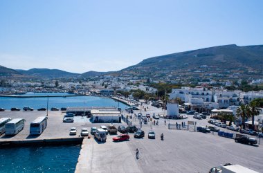 Parikia limanı, Yunanistan 'ın Paros adası. İşlek rıhtımların manzara görüntüsü feribotlara binmeyi bekleyen araçlar ve yolcular gibi. Mavi gökyüzü - Boşluğu kopyala.  