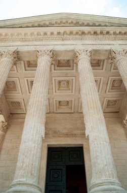 Nimes, Fransa. Antik Roma Maison Carree 'nin dramatik manzarası. Bu büyüleyici Fransız şehrinin kalbinde mükemmel korunmuş bir tapınağın alçak açılı görüntüsü. Portre açılı çekim. Boşluğu kopyala.  