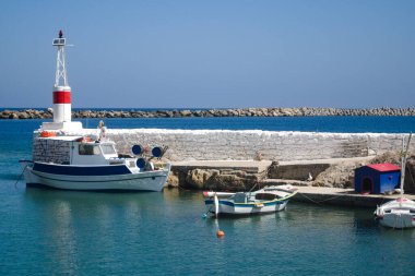 Yunanistan, tenha Kassos adası. Cuma günkü köy manzarası limanında renkli geleneksel balıkçı tekneleri. Mavi gökyüzü ve boşluk kopyala.