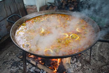 Fresh Spanish paella cooking in a pan at a beach restaurant, Nerja, Andalusia, Spain. High angle shot - close up view. 