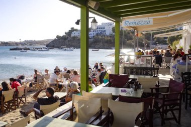 Paros Adası - Yunanistan - 22 Eylül 2019: Tatilciler Piso Livadi adlı küçük bir köyde bir sahil barında dinleniyorlar. Yaz sahnesini geride bıraktım. Manzara görünümü görüntüsü. 