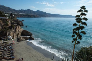 Nerja İspanya 22 Eylül 2021: El değmemiş kumların yaz sahnesi manzarası Tatilciler güzel sahil ve mavi denizin tadını çıkarıyor