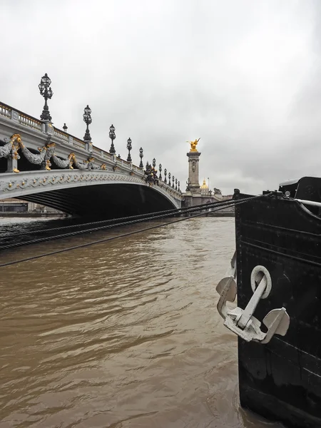 Мост Александра III с рекой Сена и кораблем на переднем плане в Париже, Франция — стоковое фото