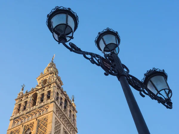 Sevilla, Andalusia, Spagna: Giralda e vecchia lampada davanti al cielo blu — Foto Stock