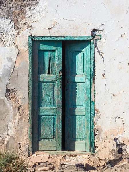 Старый гнилой дом с деревянной зеленой дверью — стоковое фото