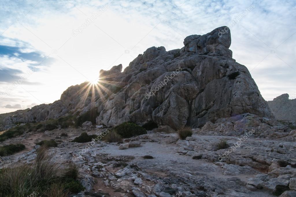 Sunbeams behind a rock