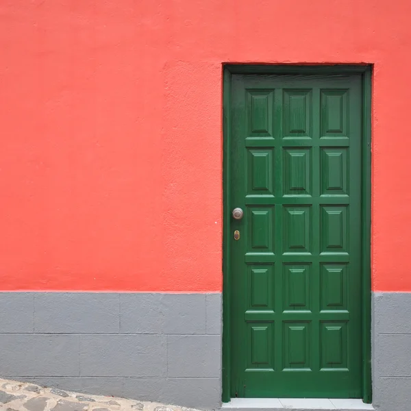 Красный дом с деревянной зеленой дверью — стоковое фото