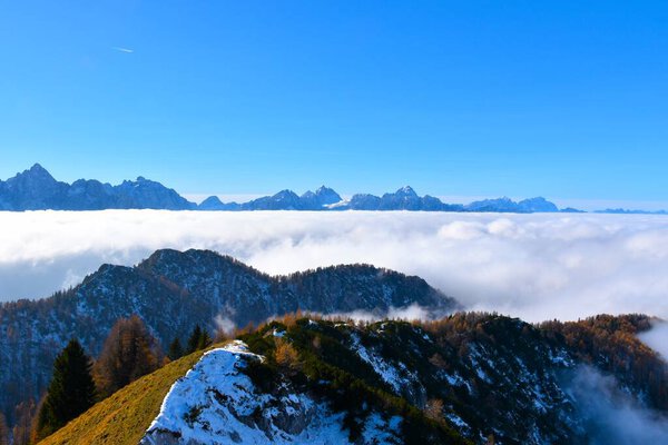Ridge in in Karavanke mountains and a view of Julian alps above the clouds inGorenjska, Slovenia