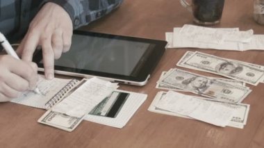 Erkek dijital tablet kullanarak faturaları dikkate alır.