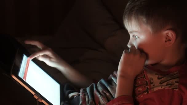 Мальчик наслаждается цифровым планшетом по ночам — стоковое видео