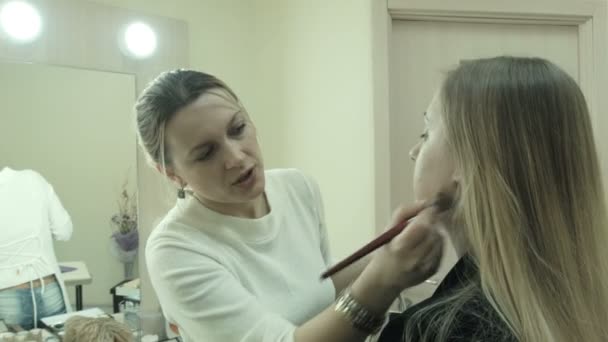 Maquilleuse appliquant du maquillage sur un client — Video