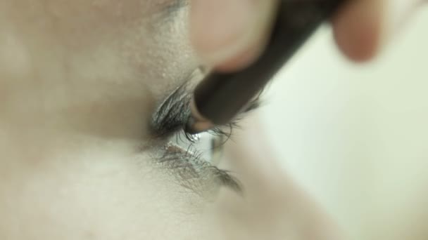 Makeup artist applying eyeliner on eyelid. — Stock Video