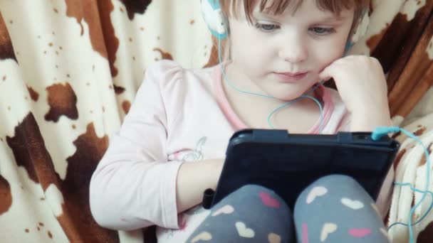 Pouco bonito menina assistir vídeo no tablet digital — Vídeo de Stock